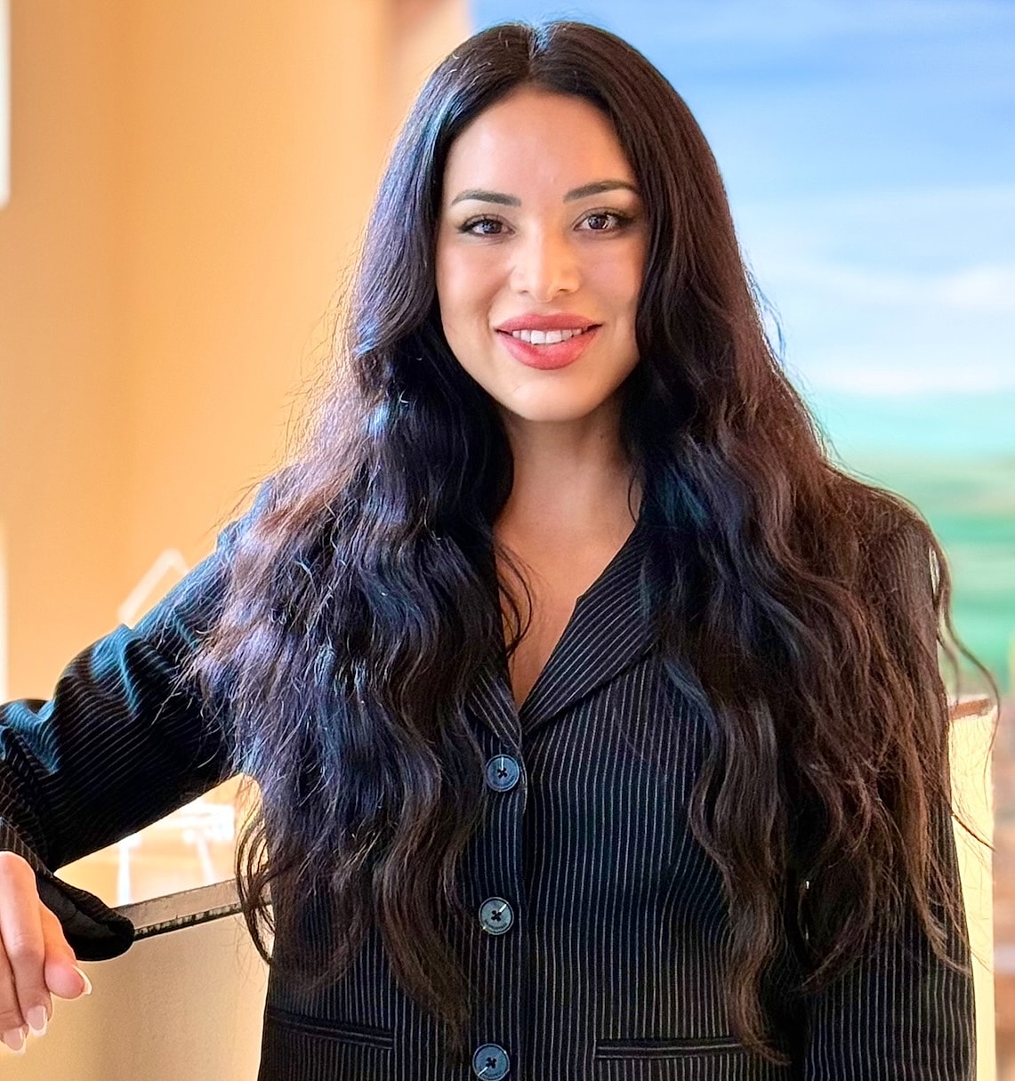 Professional woman in a black blazer, smiling.