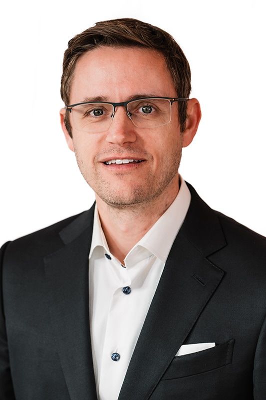 Smiling man in a business suit and glasses.