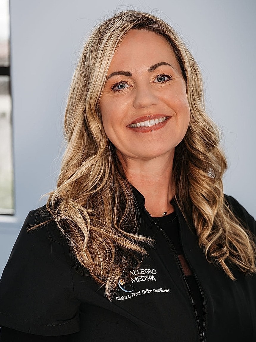 Smiling woman in medical attire, front office coordinator.