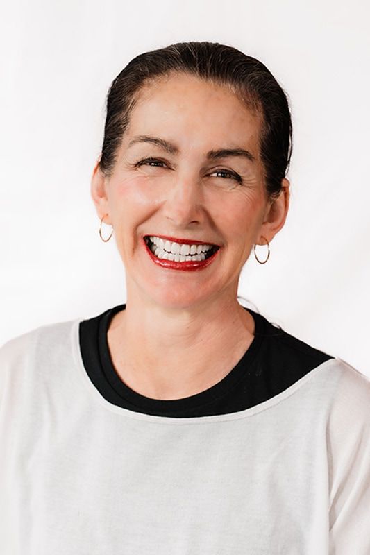 Smiling woman with long hair and earrings.