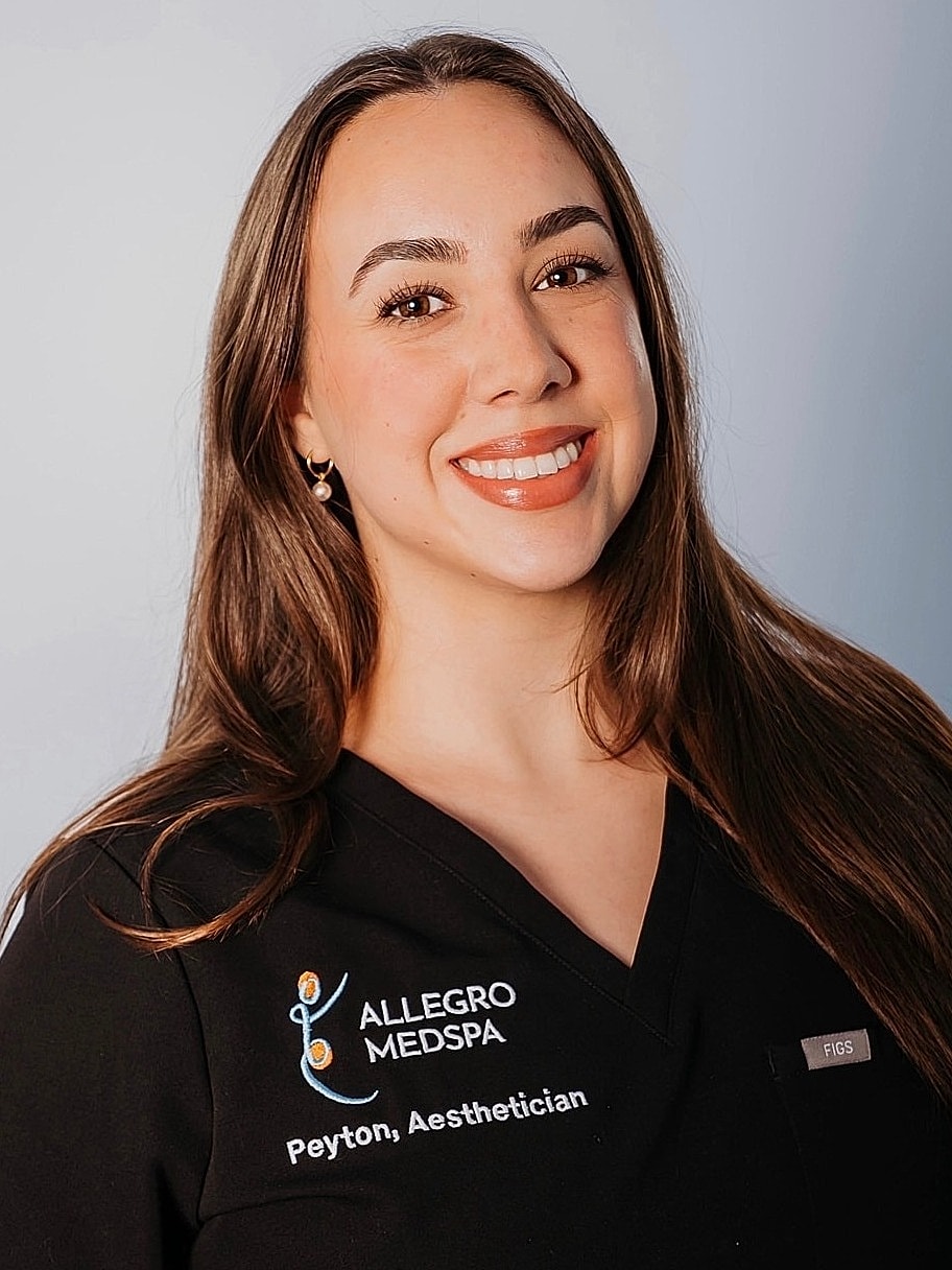 Aesthetician smiling in professional attire.