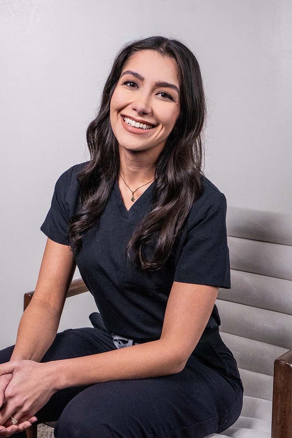 Smiling woman with long dark hair in sweater.