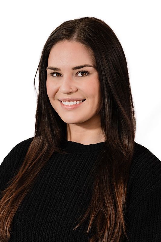 Woman with long hair smiling in black sweater.