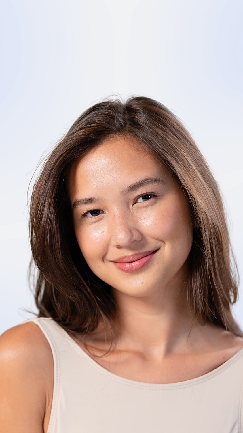 Smiling woman with long brown hair and natural makeup.